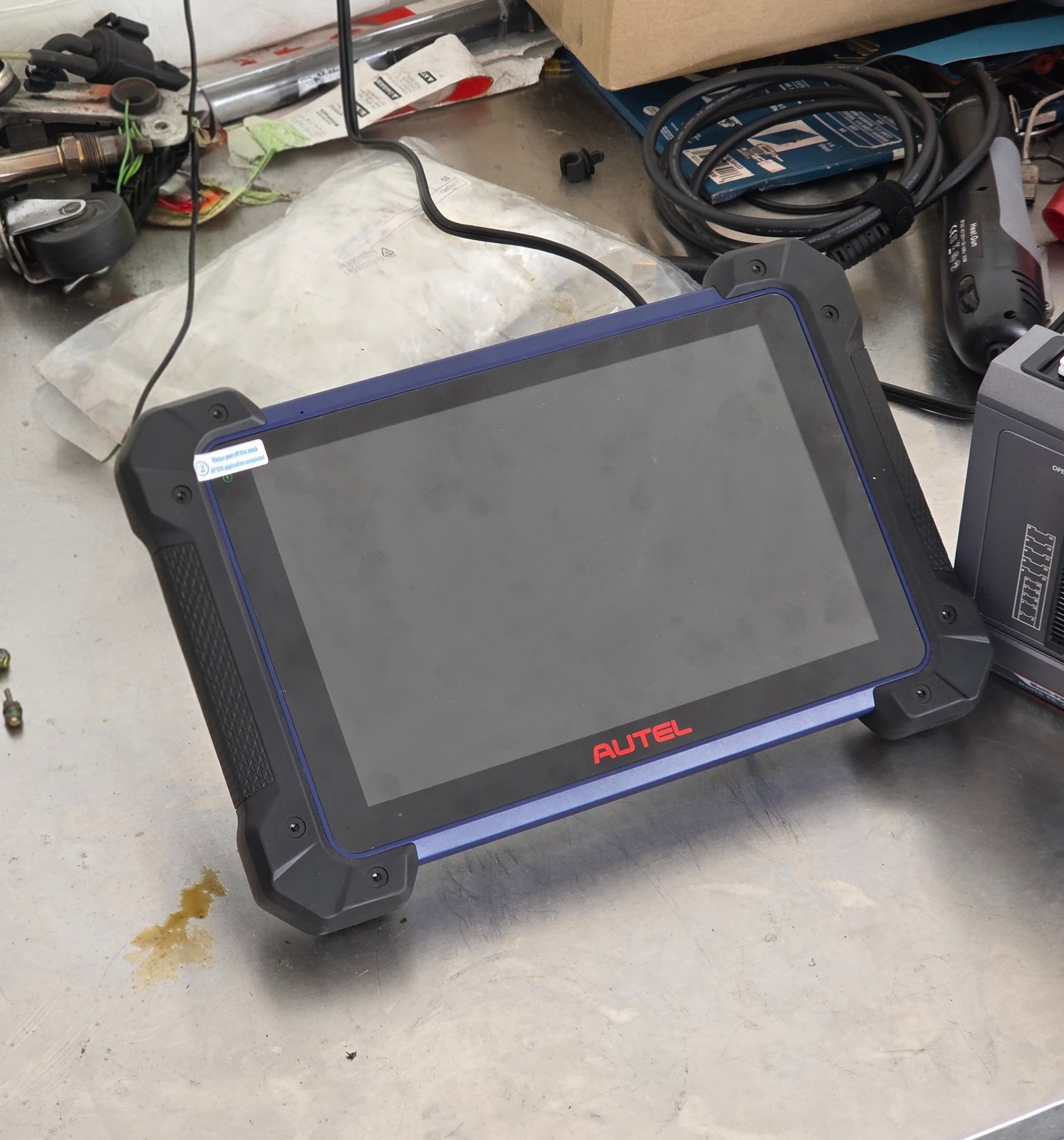 Tableta de diagnóstico Autel y equipo de prueba sobre una mesa de trabajo