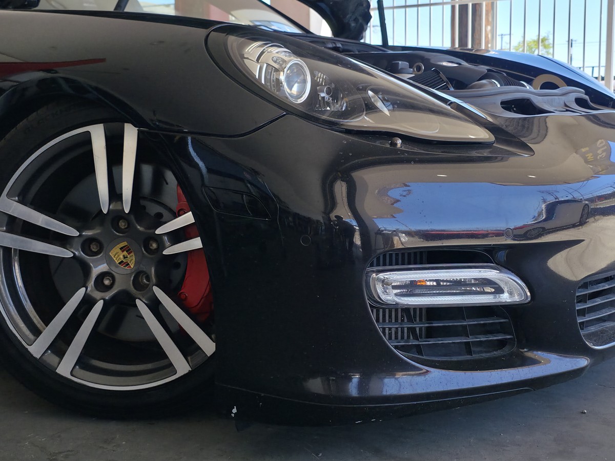 Rueda delantera de un Porsche y cáliper rojo durante el servicio de frenos