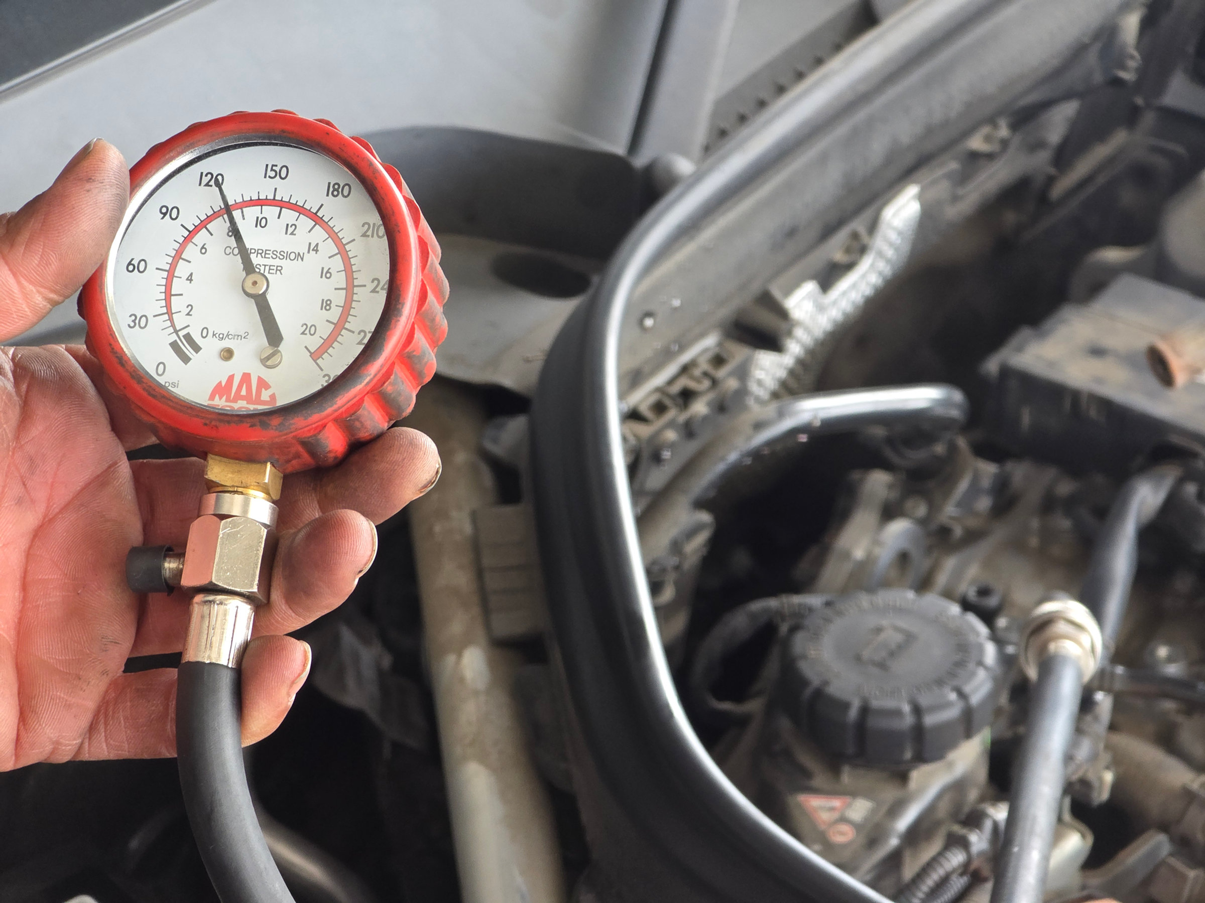 Medidor de compresión marcando cerca de 120 psi durante un diagnóstico de motor